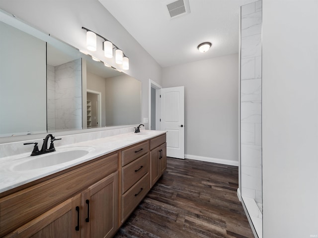 bathroom with hardwood / wood-style floors, walk in shower, and vanity