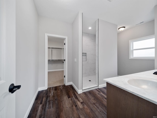 bathroom with hardwood / wood-style floors, vanity, and an enclosed shower