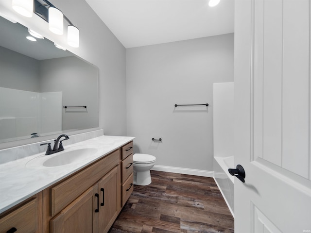 full bathroom with toilet, plus walk in shower, vanity, and hardwood / wood-style flooring