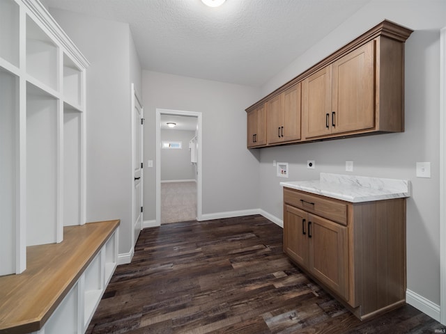 laundry room featuring cabinets, washer hookup, dark hardwood / wood-style floors, a textured ceiling, and hookup for an electric dryer