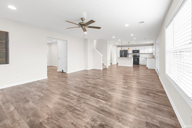 unfurnished living room featuring wood-type flooring and ceiling fan