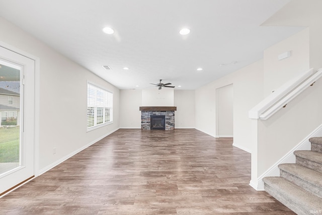 unfurnished living room with a fireplace, wood-type flooring, and ceiling fan