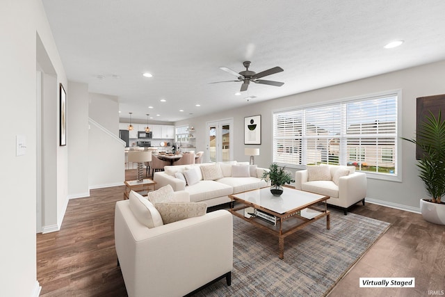 living room with ceiling fan, a textured ceiling, and dark hardwood / wood-style flooring