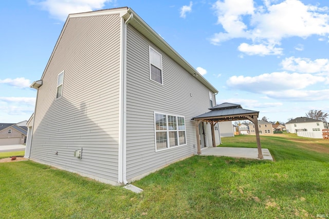 back of property with a lawn, a patio, and a gazebo