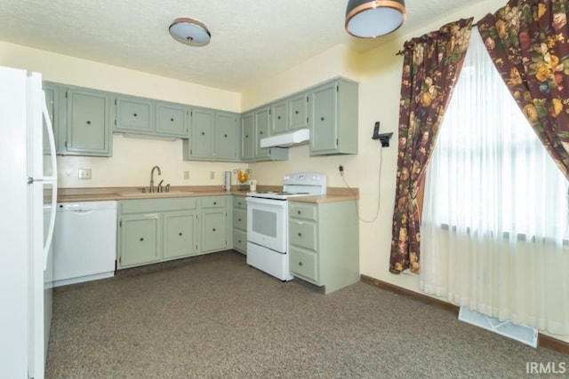 kitchen featuring a wealth of natural light, white appliances, sink, and green cabinets