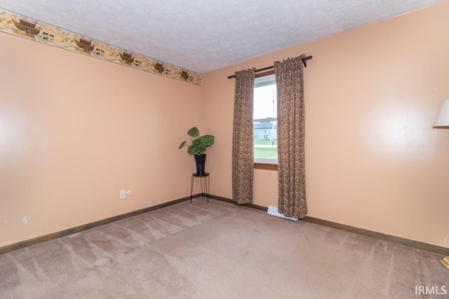 carpeted spare room featuring a textured ceiling