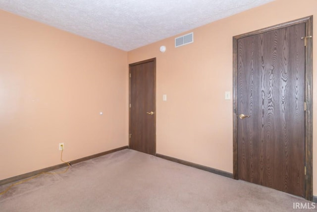 carpeted spare room with a textured ceiling