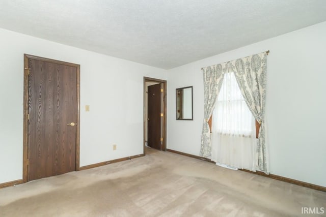 spare room featuring light colored carpet