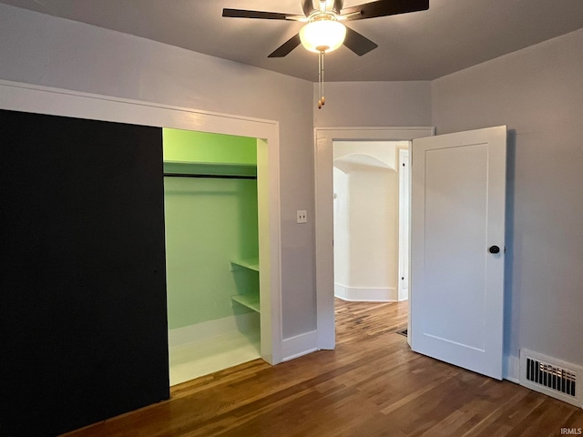 unfurnished bedroom with ceiling fan, wood-type flooring, and a closet