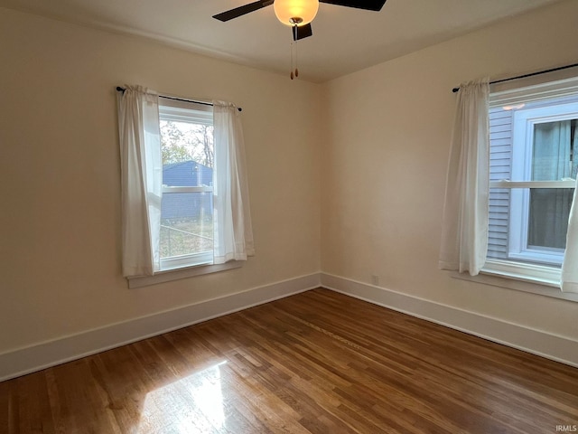 empty room with hardwood / wood-style floors and ceiling fan