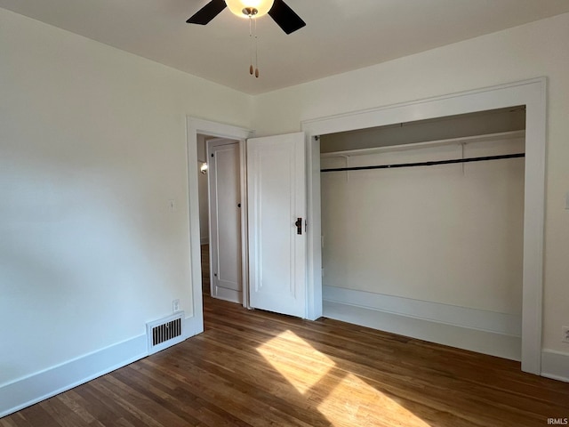 unfurnished bedroom featuring ceiling fan, dark hardwood / wood-style floors, and a closet