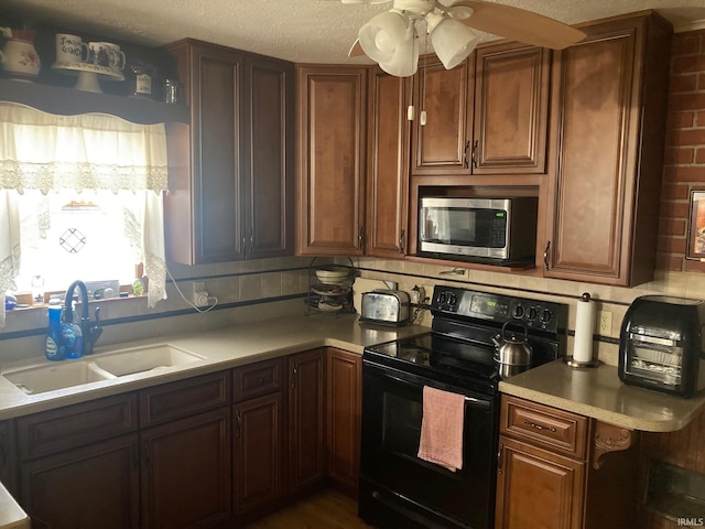 kitchen featuring ceiling fan, decorative backsplash, sink, and black electric range