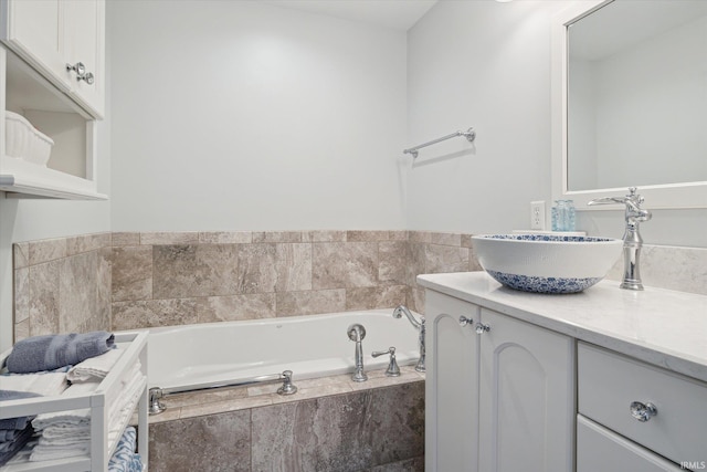 bathroom featuring vanity and tiled tub