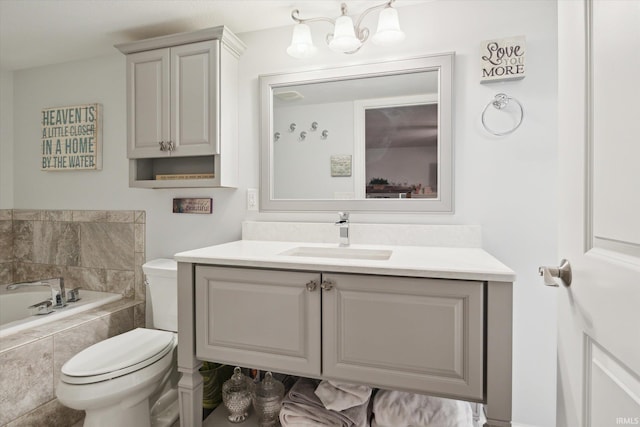 bathroom with vanity, toilet, and tiled tub