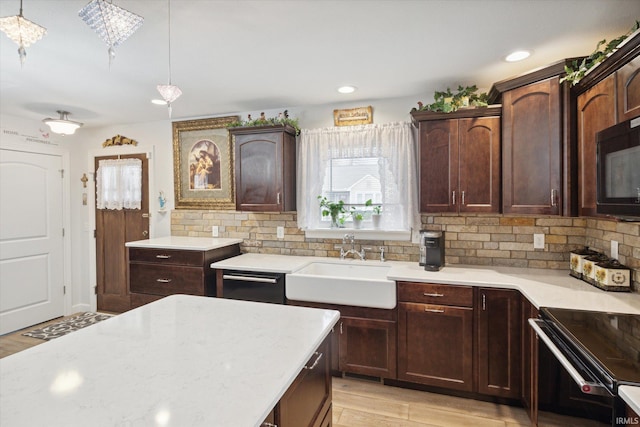 kitchen featuring black appliances, backsplash, light wood-type flooring, pendant lighting, and sink