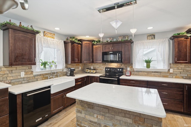 kitchen with sink, black appliances, decorative light fixtures, light wood-type flooring, and decorative backsplash