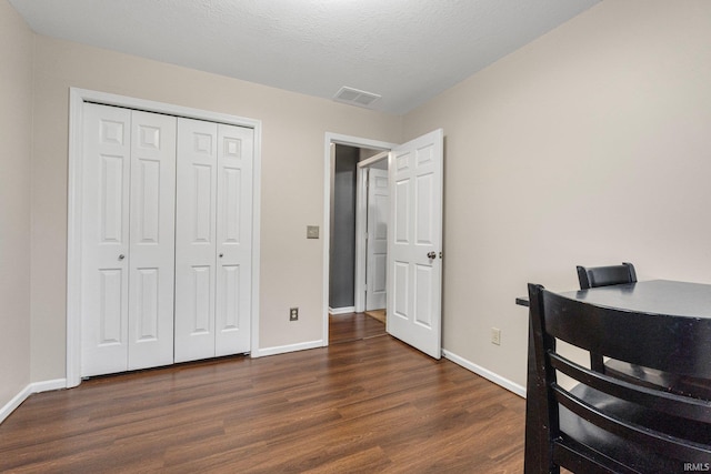 home office featuring dark wood-type flooring and a textured ceiling