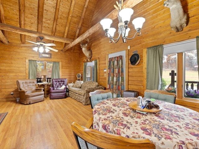 dining space featuring light hardwood / wood-style flooring, wood walls, beam ceiling, and plenty of natural light