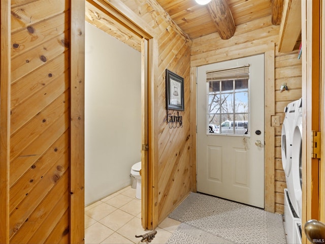 doorway with wood walls, light tile patterned floors, independent washer and dryer, and wooden ceiling