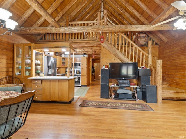 kitchen with stainless steel appliances, wooden walls, high vaulted ceiling, beamed ceiling, and light wood-type flooring