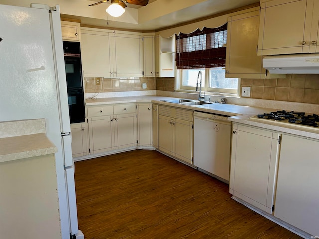 kitchen featuring tasteful backsplash, sink, dark hardwood / wood-style floors, and white appliances