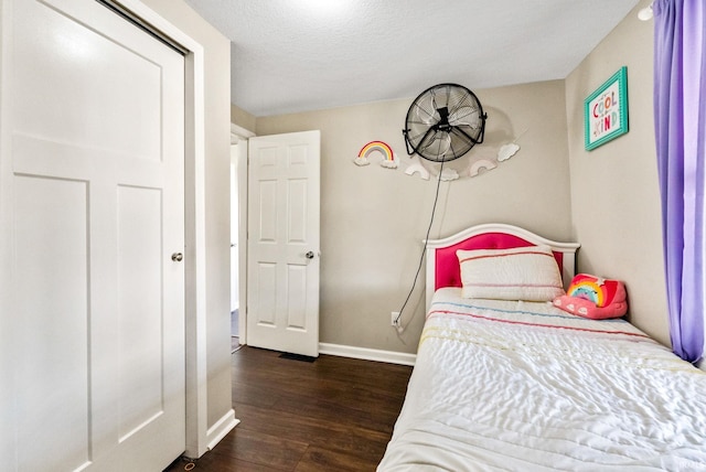 bedroom with dark hardwood / wood-style floors and a textured ceiling