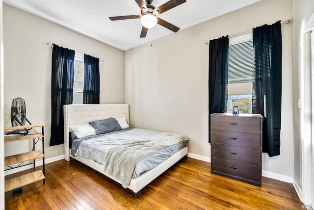 bedroom with hardwood / wood-style floors, multiple windows, and ceiling fan