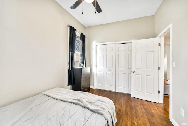 bedroom with dark wood-type flooring, ceiling fan, and a closet