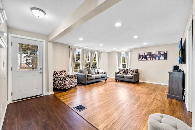 living room with wood-type flooring and a textured ceiling