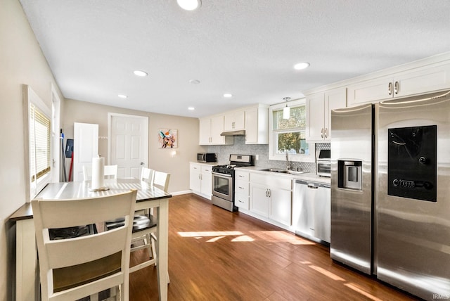 kitchen featuring stainless steel appliances, a wealth of natural light, and white cabinets