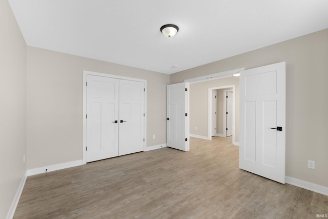 unfurnished bedroom featuring light hardwood / wood-style flooring and a closet