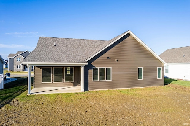 rear view of property with a lawn and a patio