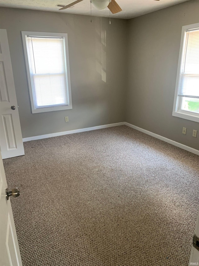 carpeted spare room featuring ceiling fan