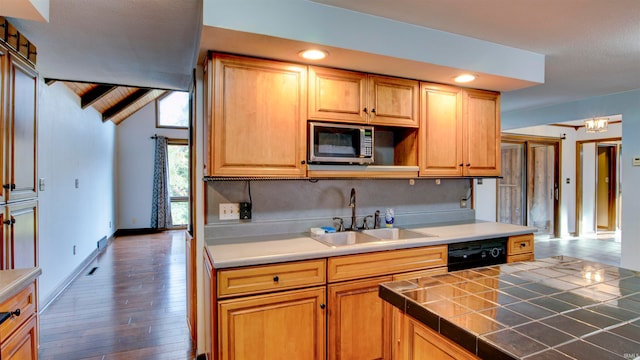 kitchen featuring tile counters, dark hardwood / wood-style flooring, dishwasher, sink, and lofted ceiling with beams