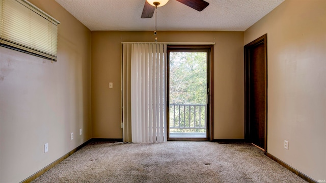 carpeted empty room featuring a textured ceiling and ceiling fan