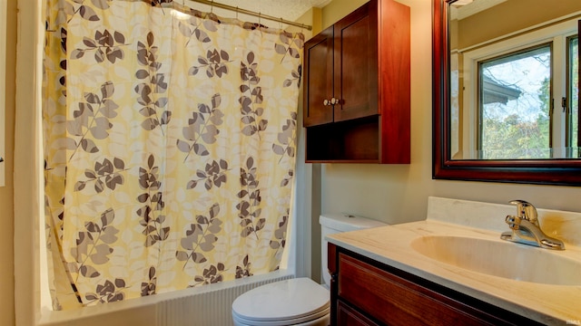 full bathroom with shower / bath combo, vanity, toilet, and a textured ceiling