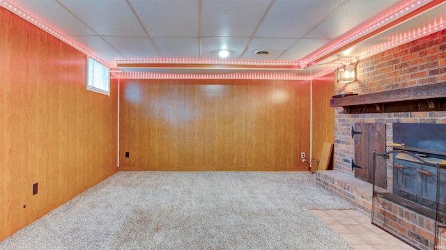 basement with a drop ceiling and wooden walls