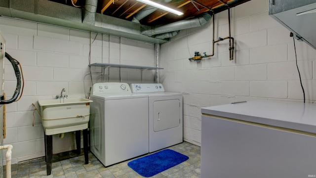 clothes washing area featuring washer and dryer and sink