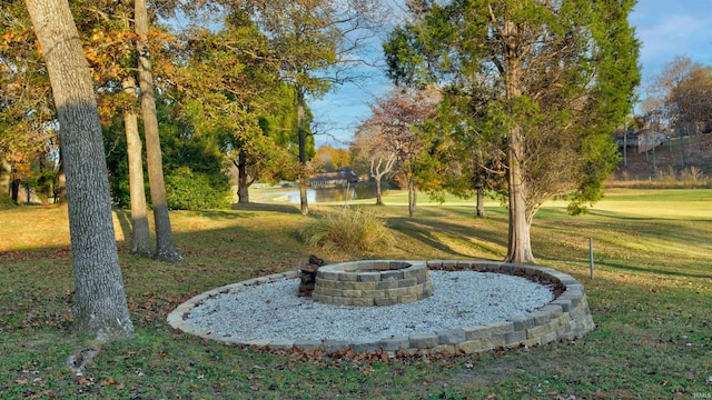 view of property's community featuring a lawn and a fire pit