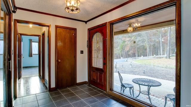 foyer entrance with dark tile patterned floors, a healthy amount of sunlight, and a textured ceiling