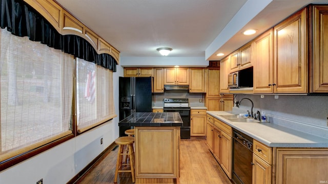 856 S Balthazar Dr, Santa Claus, IN 47579 - kitchen featuring black appliances, a sink, a kitchen bar, light wood-type flooring, and a kitchen island