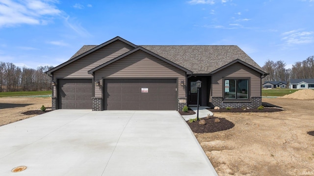view of front of house with an attached garage, driveway, brick siding, and roof with shingles