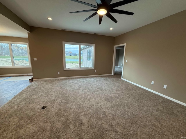 carpeted spare room featuring plenty of natural light and ceiling fan