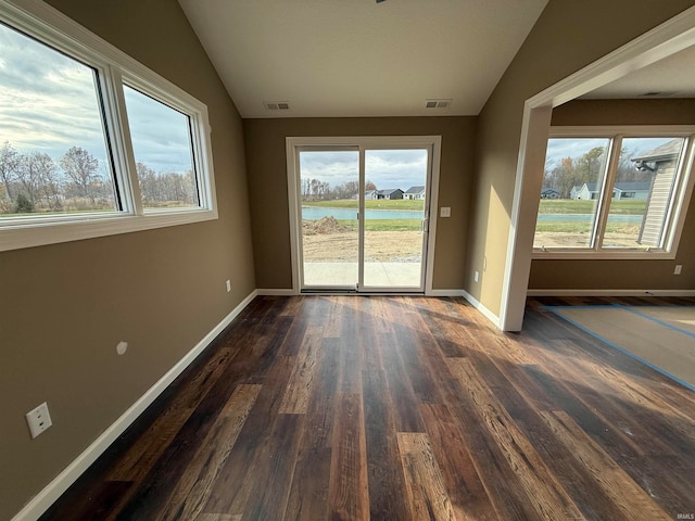 unfurnished room with a water view, dark hardwood / wood-style floors, and vaulted ceiling