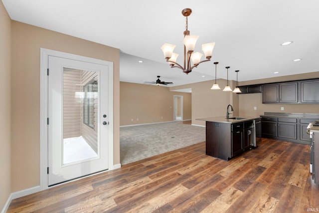 kitchen with a chandelier, hanging light fixtures, open floor plan, stainless steel dishwasher, and baseboards