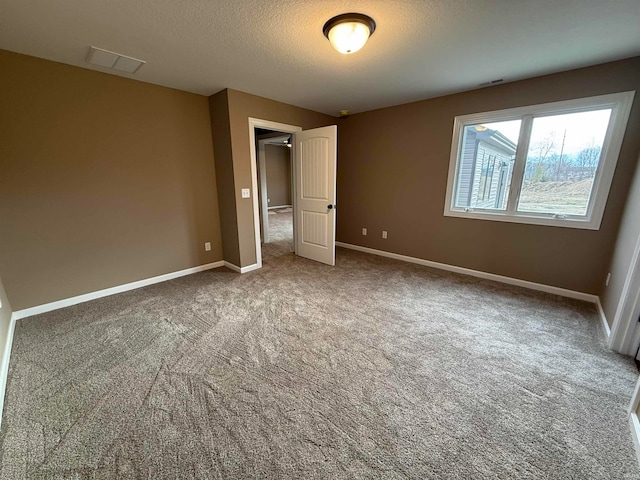 unfurnished bedroom with carpet flooring and a textured ceiling