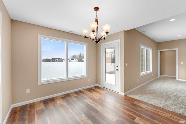 unfurnished dining area featuring a chandelier, baseboards, wood finished floors, and recessed lighting