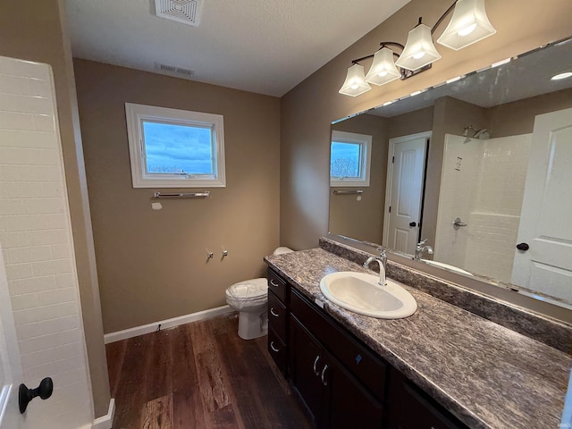 bathroom featuring vanity, toilet, hardwood / wood-style floors, and a shower