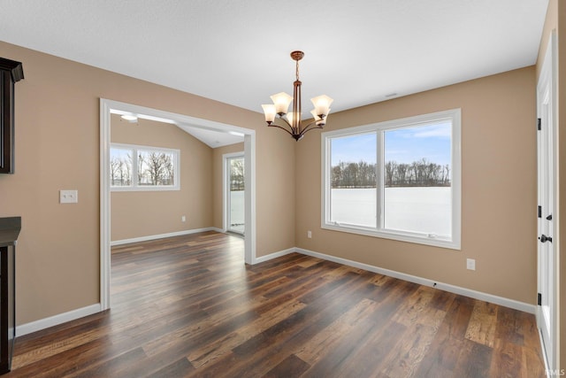 empty room with a chandelier, dark wood-type flooring, and baseboards