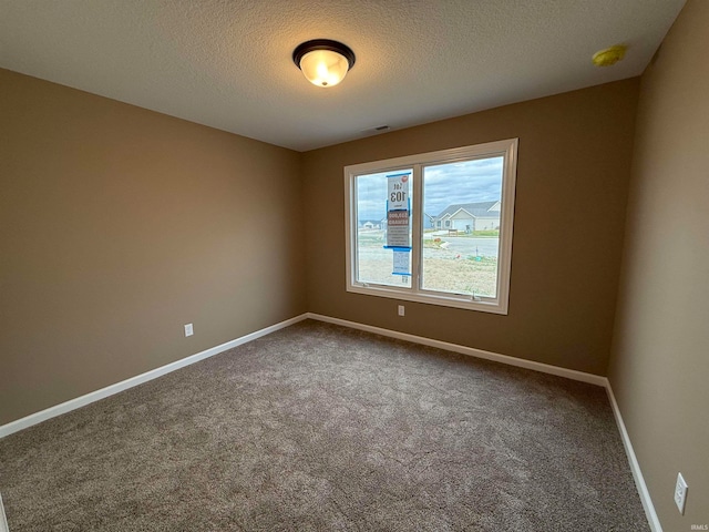 spare room featuring a textured ceiling and carpet flooring